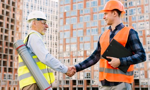 side-view-men-with-safety-vests-shaking-hands